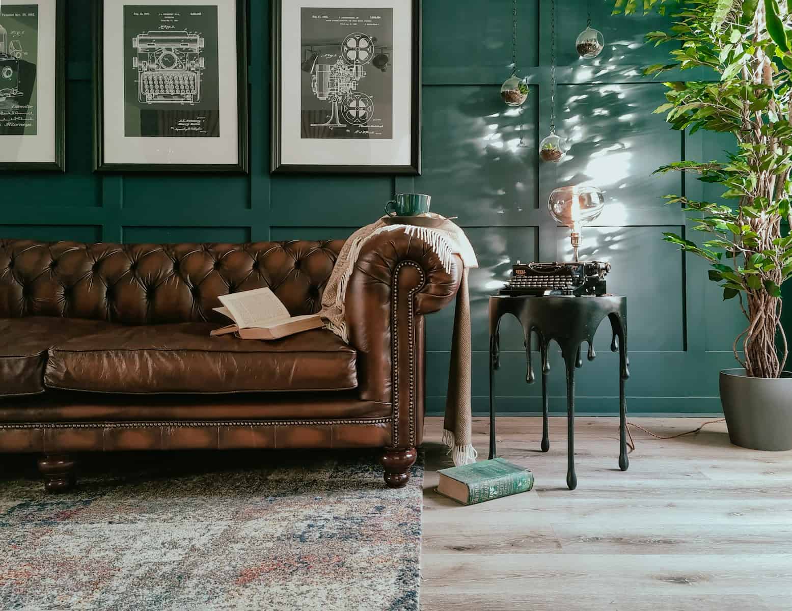 a living room with a brown leather couch and a potted plant