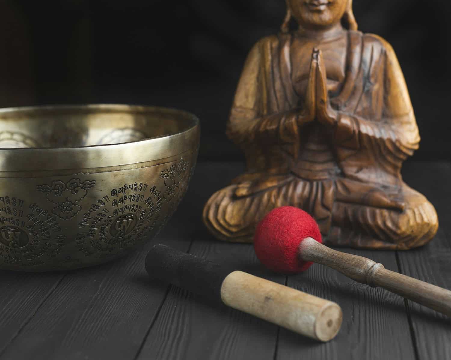Photo by petr sidorov brass buddha figurine beside red and white stick